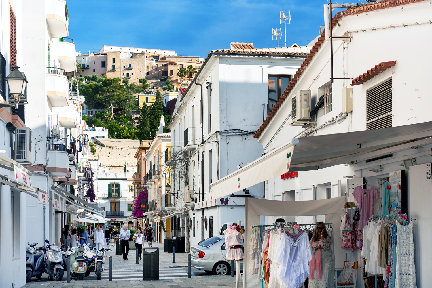 Tourists walking in the charming whitewashed narrow street in Ibiza old town